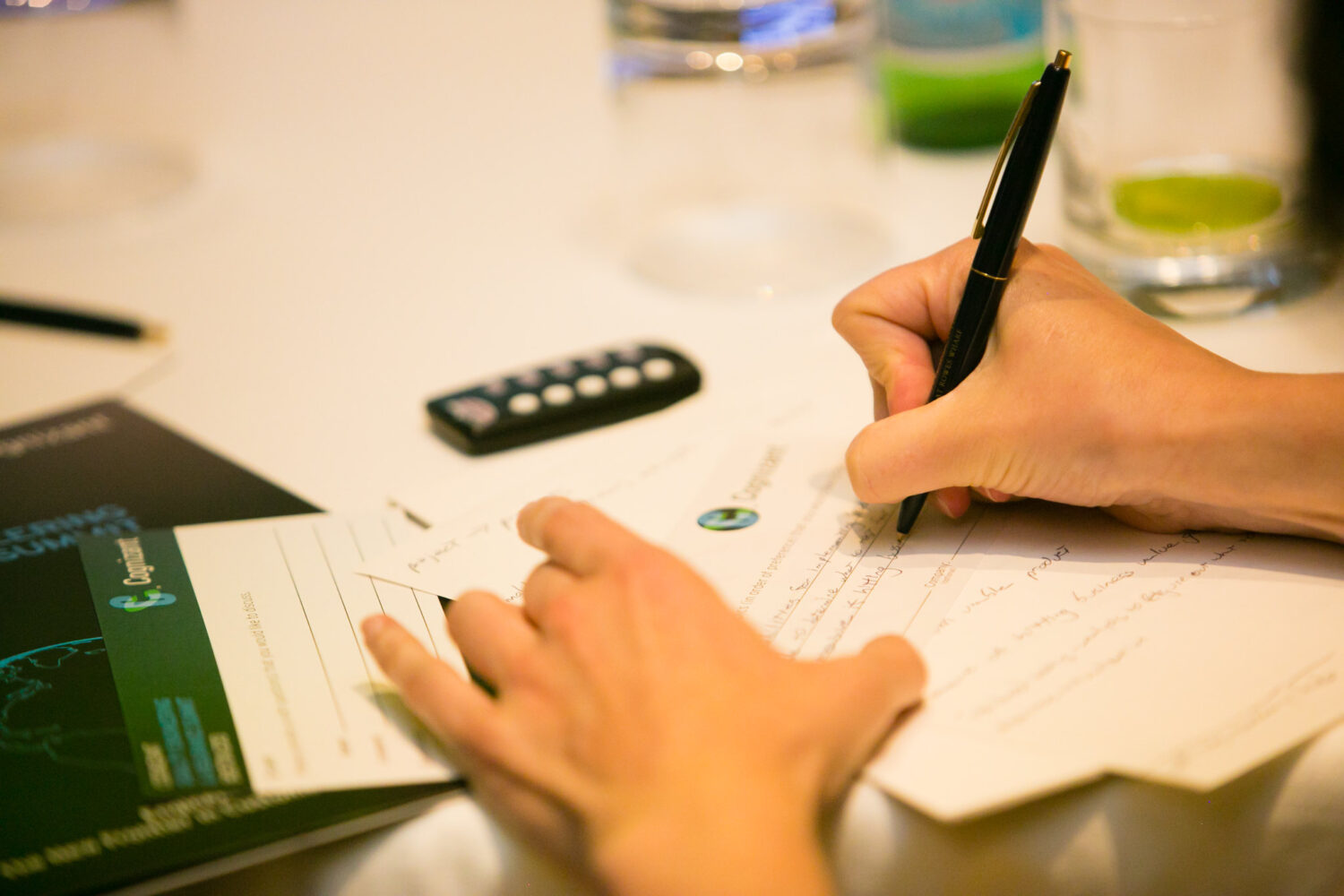 Person writing notes on paper during a strategic marketing meeting, emphasizing the importance of adaptability in business strategies.