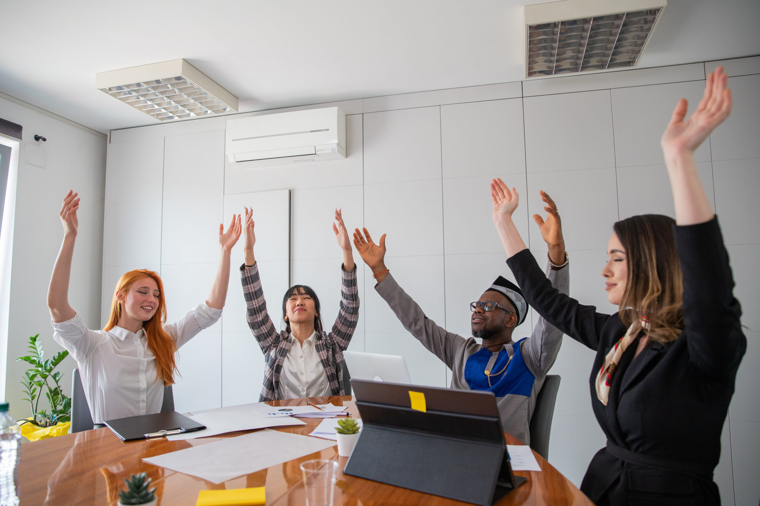 A group of HVAC business people with their hands raised working on digital marketing for their heating and cooling company